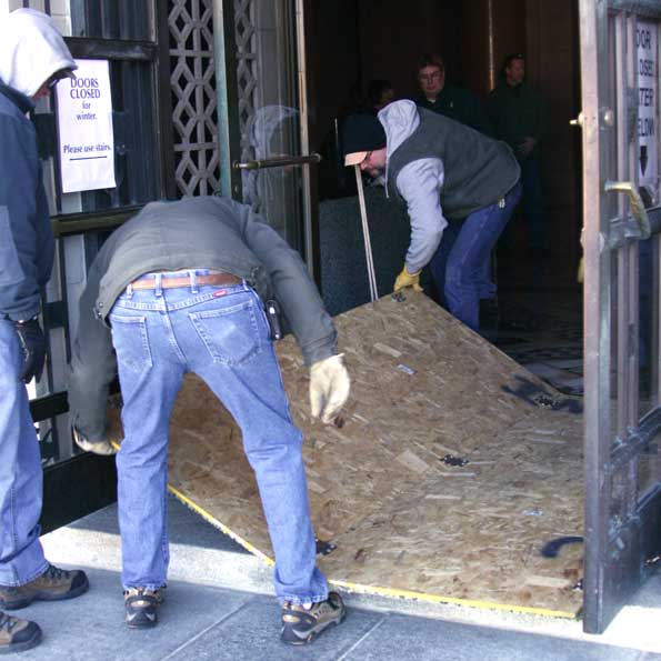 Capitol Commission staff members erect a wooden frame to protect the Capitol's entrance.